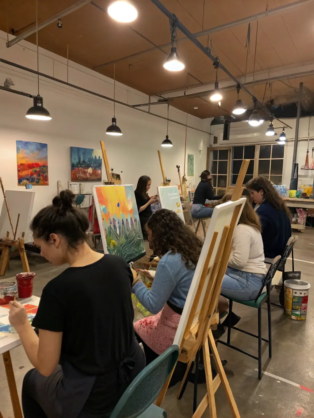 A photograph of a professional development workshop for artists, showing participants actively engaged in learning new techniques and networking with peers in a modern studio.